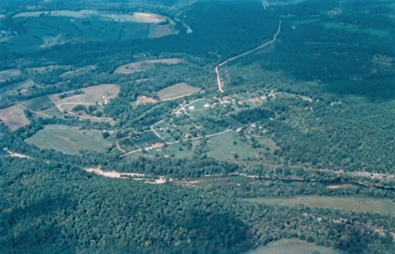 An aerial view shows the Buffalo River winding past Gilbert with wooded hills and gravel bars nearby.