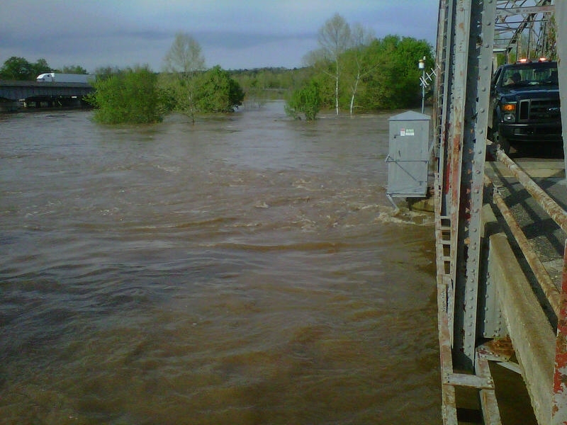 The Gasconade River runs high near Hazelgreen, Missouri, beside a bridge and wooded riverbank.