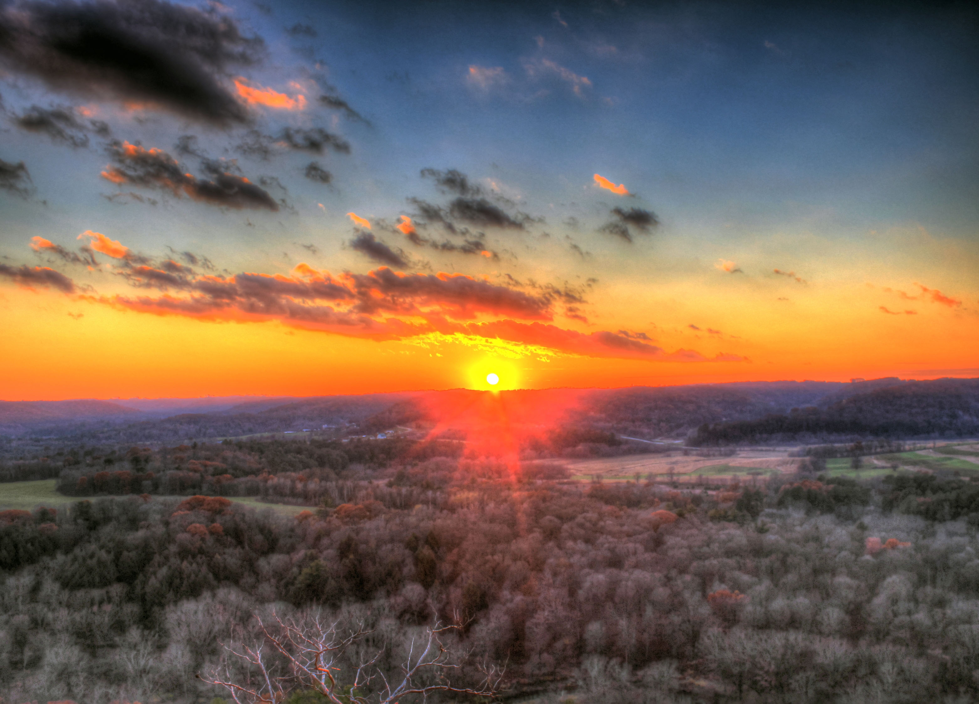 The Kickapoo River valley stretches below wooded hills at sunset in the Driftless Area.