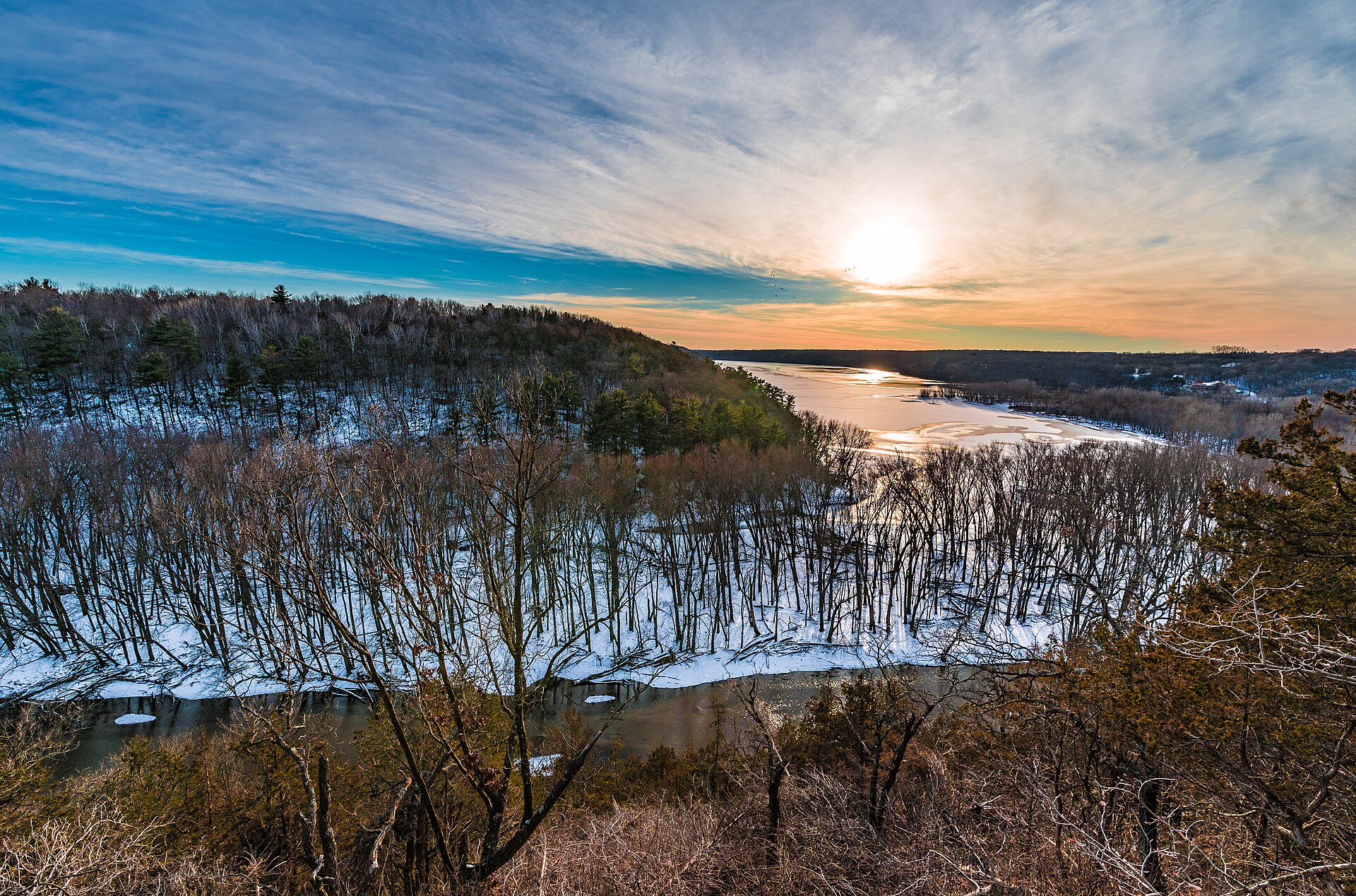A winter sunset glows over the Kinnickinnic River where it meets the St. Croix River near Kinnickinnic State Park.