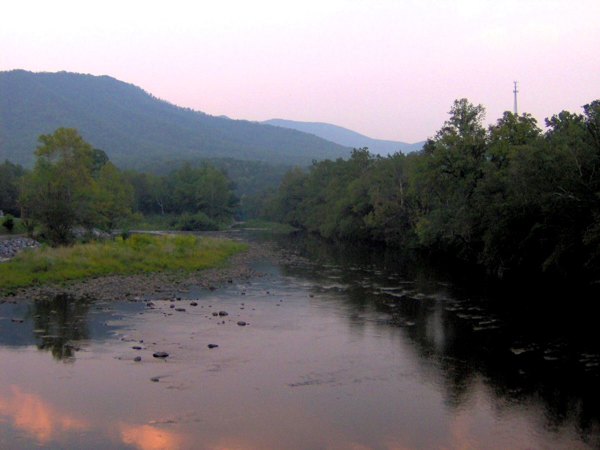 The Pigeon River runs through Hartford, Tennessee, with forested banks and whitewater current below the road.