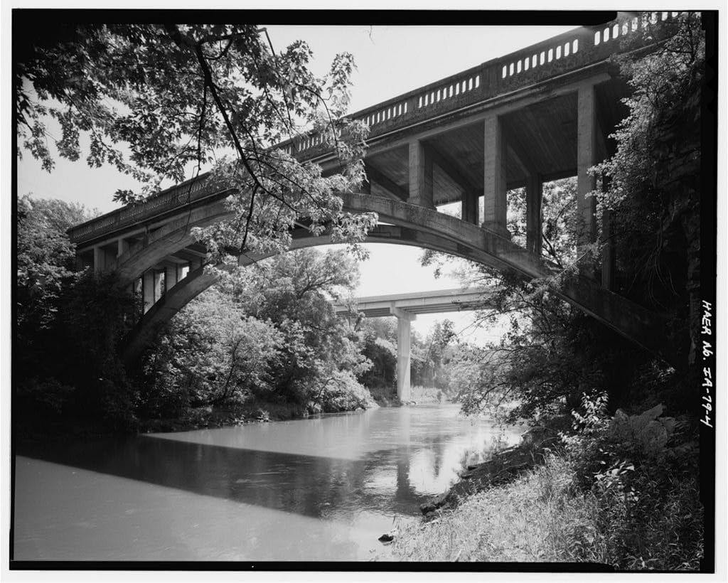 The Mederville Bridge spans the Volga River from a river-edge view, with wooded banks around the crossing.